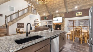 A spacious kitchen with a granite countertop, stainless steel appliances, and a wooden dining area.