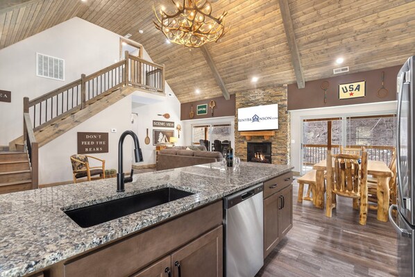 A spacious kitchen with a granite countertop, stainless steel appliances, and a fireplace.