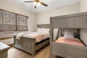 A bedroom with a bed, a window with blinds, a ceiling fan, and a wooden floor. - Near Thunder Ridge with Free Attraction Tickets, Wood Fireplace & Community Indoor Pool (Hollister)