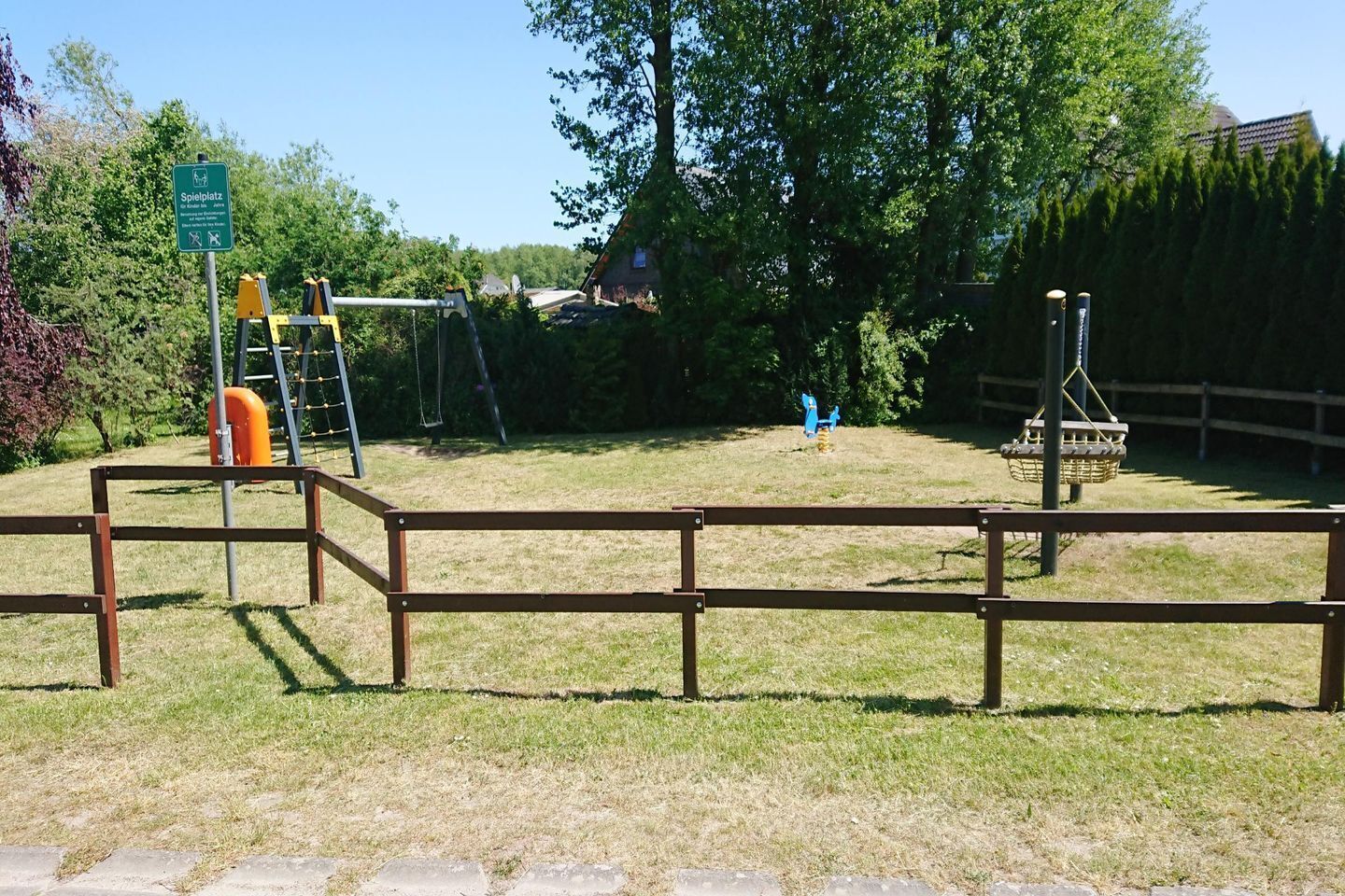 A playground with swings, a slide, and a climbing structure.