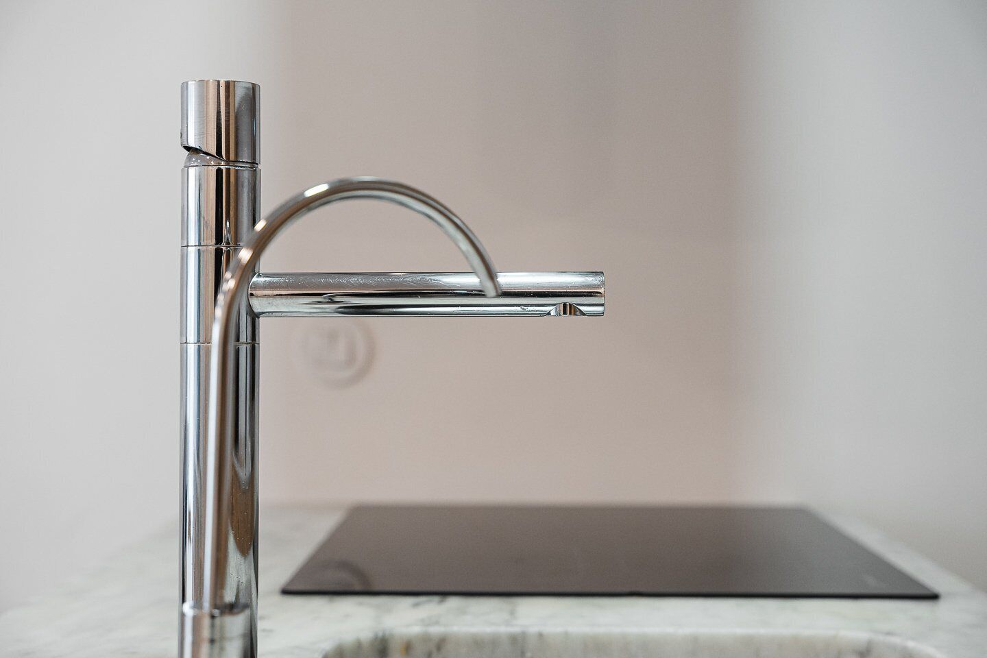 Un baño moderno con grifo de cromo y un lavabo minimalista.