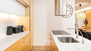 Een moderne keuken met een roestvrijstalen spoelbak, houten keukenkastjes en een inbouwoven.