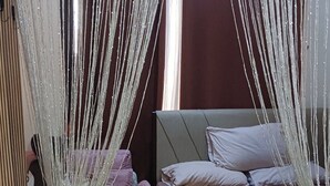 A bedroom with a bed, a nightstand, and a decorative canopy.