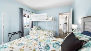 A room with a bunk bed, a desk, a chair, a mirror, and a window with a view. - Adorable Rio Del Mar Beach House - Steps to beach! (Aptos)