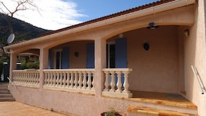 A building with a covered porch, a satellite dish, and a potted plant. - Air-conditioned holiday villa 3 bedrooms sea view (CAVALAIRE SUR MER)