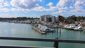 Un puerto deportivo con barcos amarrados, un edificio de varios pisos y un cielo despejado.