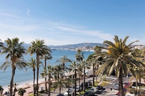 Un paysage urbain côtier avec des palmiers, une plage et une vue sur la mer.