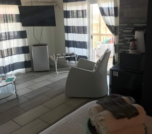 Exclusive Studio, 1 Queen Bed, Patio, Pool View | Living area | 50-inch Smart TV with digital channels