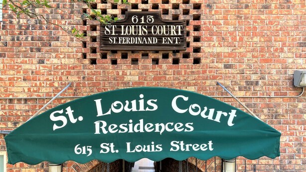 A brick building with a sign reading "St. Louis Court St. Louis Street."