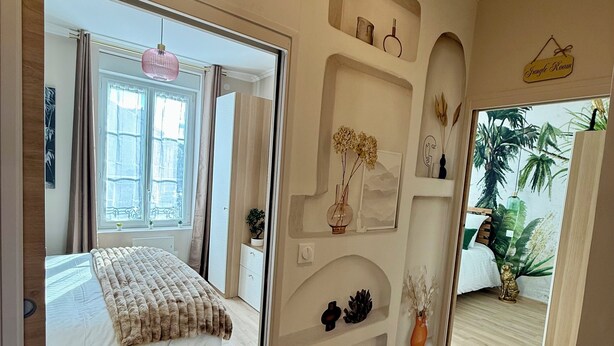 A hotel room with a bed, a mirror, a shelf with decorative items, and a sign indicating the room name. - THE REMOISED ECRIN (Reims)