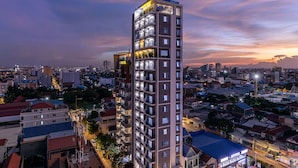 A high-rise hotel with multiple floors, balconies, and a well-lit facade.