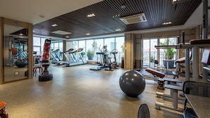 A gym with cardio machines, weightlifting equipment, and exercise balls.