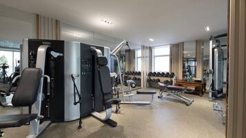 Ein modernes Fitnessstudio mit verschiedenen Trainingsgeräten, darunter Kraftgeräte und Kurzhanteln.