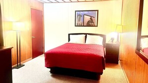 A hotel room with a bed, bedside tables, a lamp, a wardrobe, and a framed picture on the wall. - Big Red motel (Laurel)
