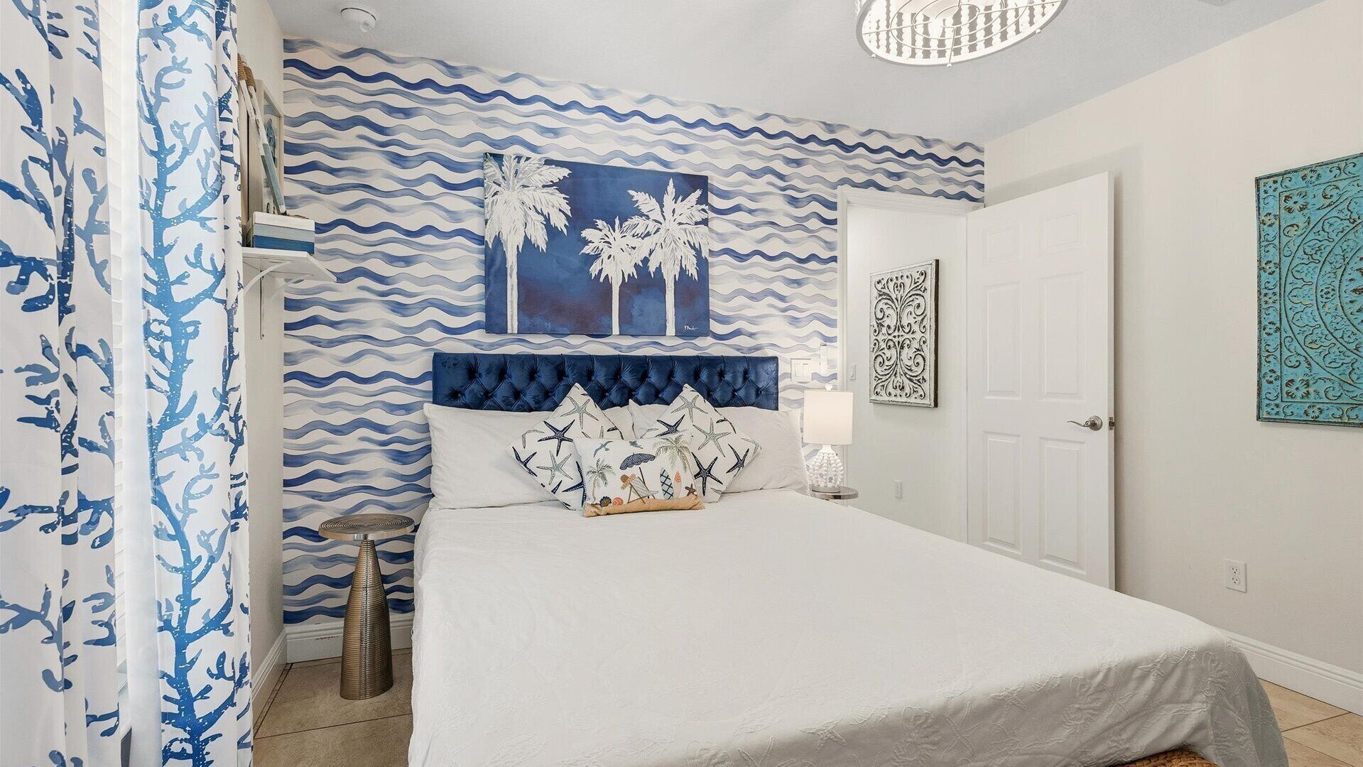 Une chambre à coucher comprenant un lit, une table de chevet, un mur décoratif aux motifs ondulés et une porte.