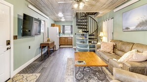 A spacious living room with a wooden coffee table, a sofa, and a ceiling fan. - Fish, Hike & More: Cozy Brainerd Cabin (Brainerd)