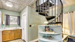 A modern kitchen with wooden cabinets, a built-in sink, and a patterned rug. - Fish, Hike & More: Cozy Brainerd Cabin (Brainerd)