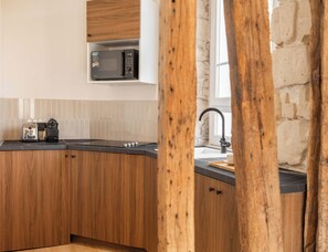 A modern kitchen with wooden cabinets, a microwave, a toaster, and a sink.