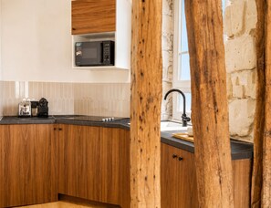 Une cuisine avec des meubles de rangement en bois, un four à micro-ondes, un grille-pain et un évier.