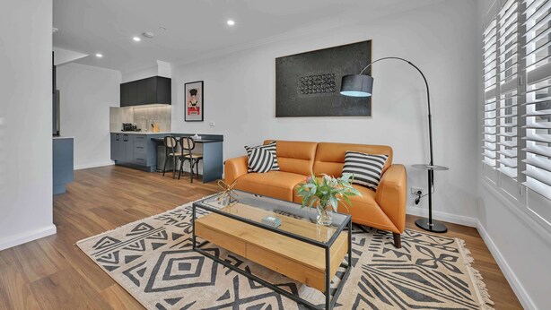 Un salon moderne avec un canapé, une table basse et une lampe sur pied.