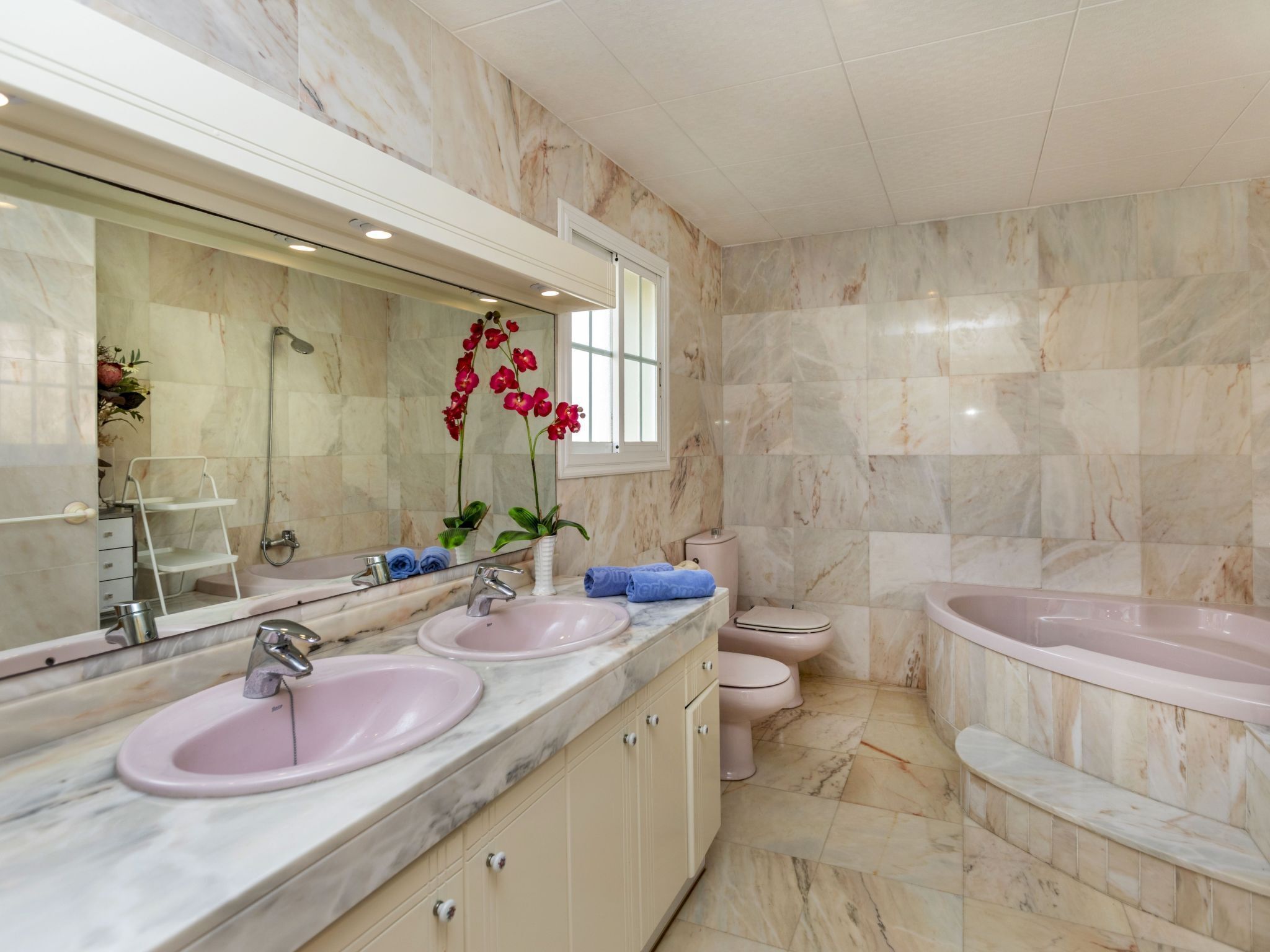 Un baño moderno con dos lavamanos, un inodoro y una bañera.