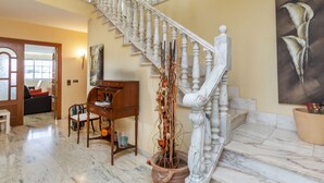 A grand staircase with white balusters and marble steps, leading to a second floor.