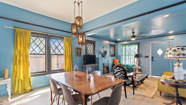 A dining area with a wooden table and chairs, a television, and a fireplace. - Stylish "NEW" Home- Hot Tub - Near Downtown, PHX Airport, and ASU (Phoenix)