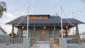 A two-story building with a flat roof, a central entrance, and a small porch with a railing. - Stylish "NEW" Home- Hot Tub - Near Downtown, PHX Airport, and ASU (Phoenix)