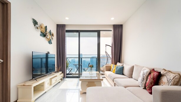 A modern living room with a flat-screen TV, a sofa, a coffee table, and a balcony with a city view. - Sunwah Pearl Suites  (Ho Chi Minh City)