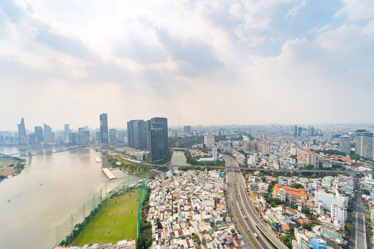 A cityscape with a river, high-rise buildings, and a densely packed residential area.