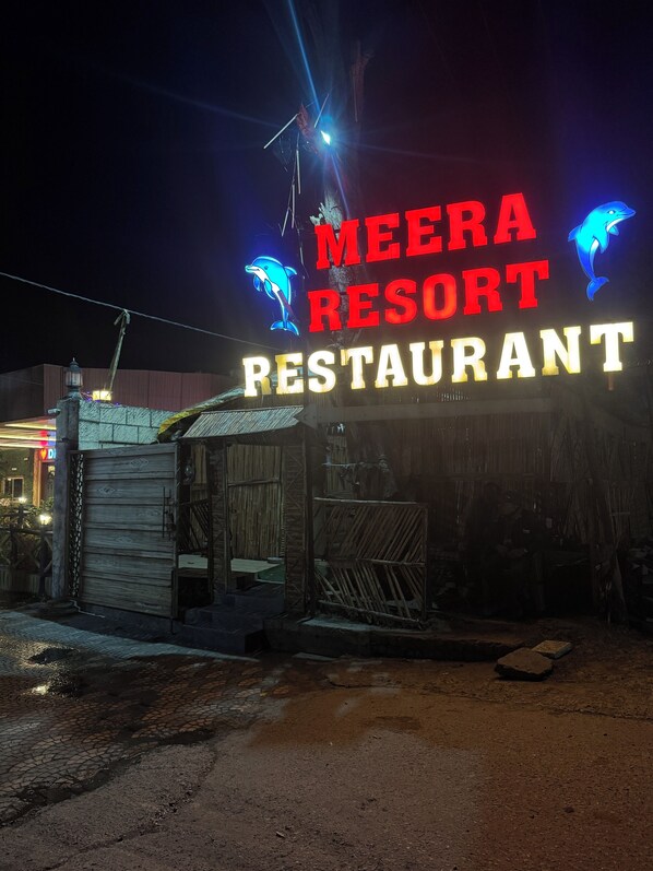 A sign for Meera Resort Restaurant with a dolphin logo.