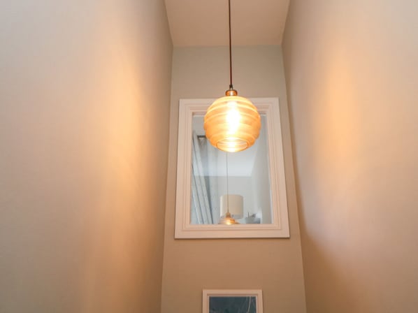 Una lámpara colgante en el techo de una habitación con ventana.