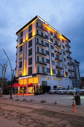 A multi-story hotel with balconies, a ground-level restaurant, and a parking area. - Başaran Rezidans & Otel (Malatya)