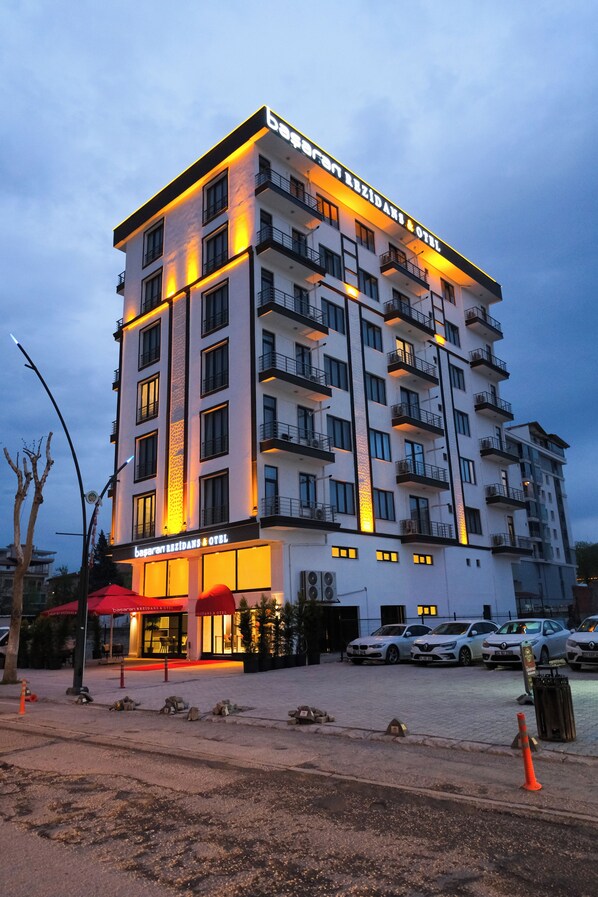 A multi-story hotel with balconies, a ground-level restaurant, and a parking area. - Başaran Rezidans & Otel (Malatya)