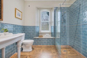 A bathroom with a shower, toilet, sink, and a window with blinds. - Huntingstile South (Ambleside)