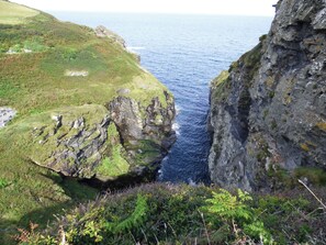 A coastal landscape with rocky cliffs and a narrow sea passage.