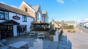 A traditional pub with outdoor seating and a stone facade. - Mews Cottage (Tintagel)