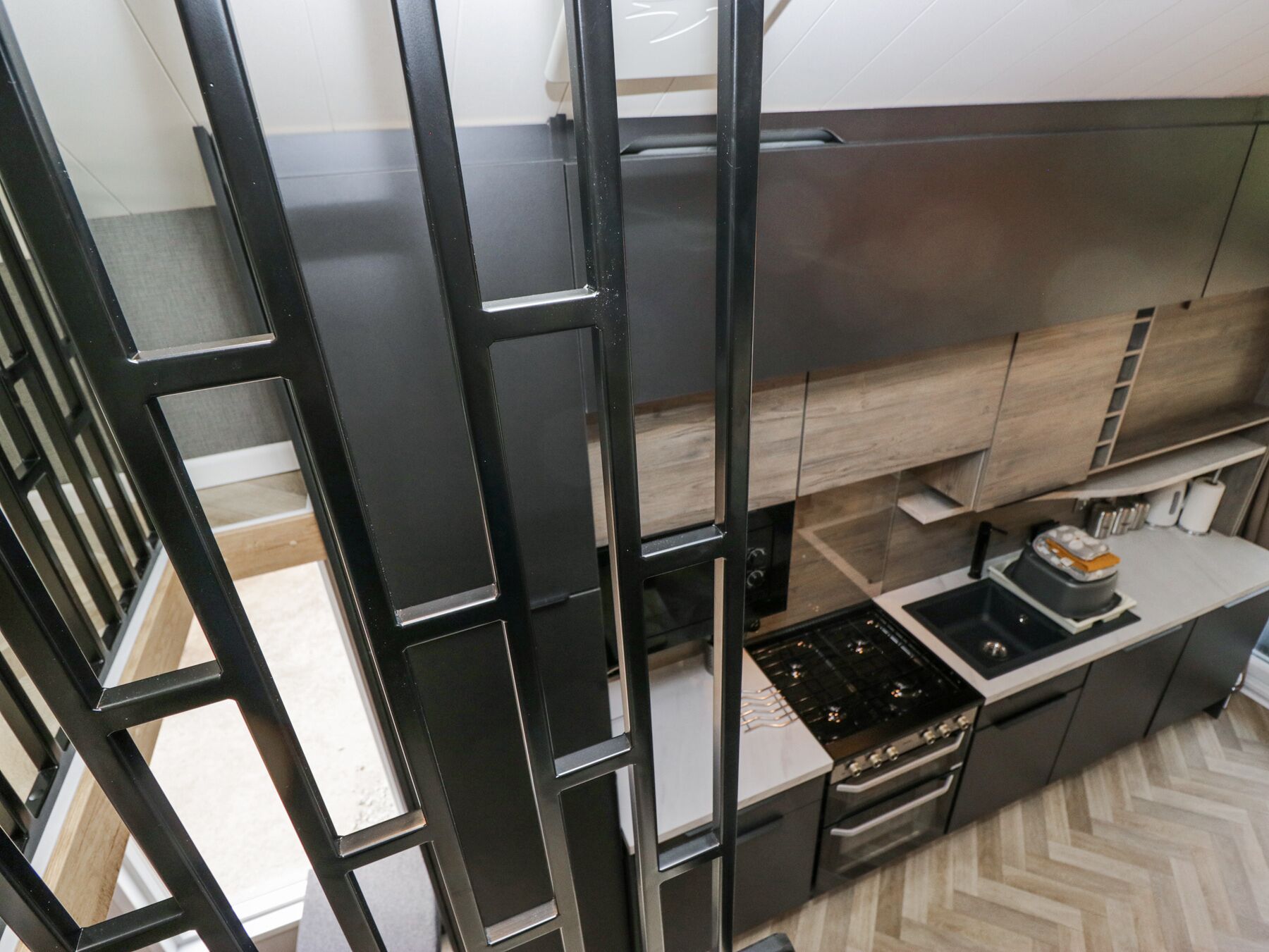 A modern kitchen with a built-in stove, oven, and wooden cabinets.