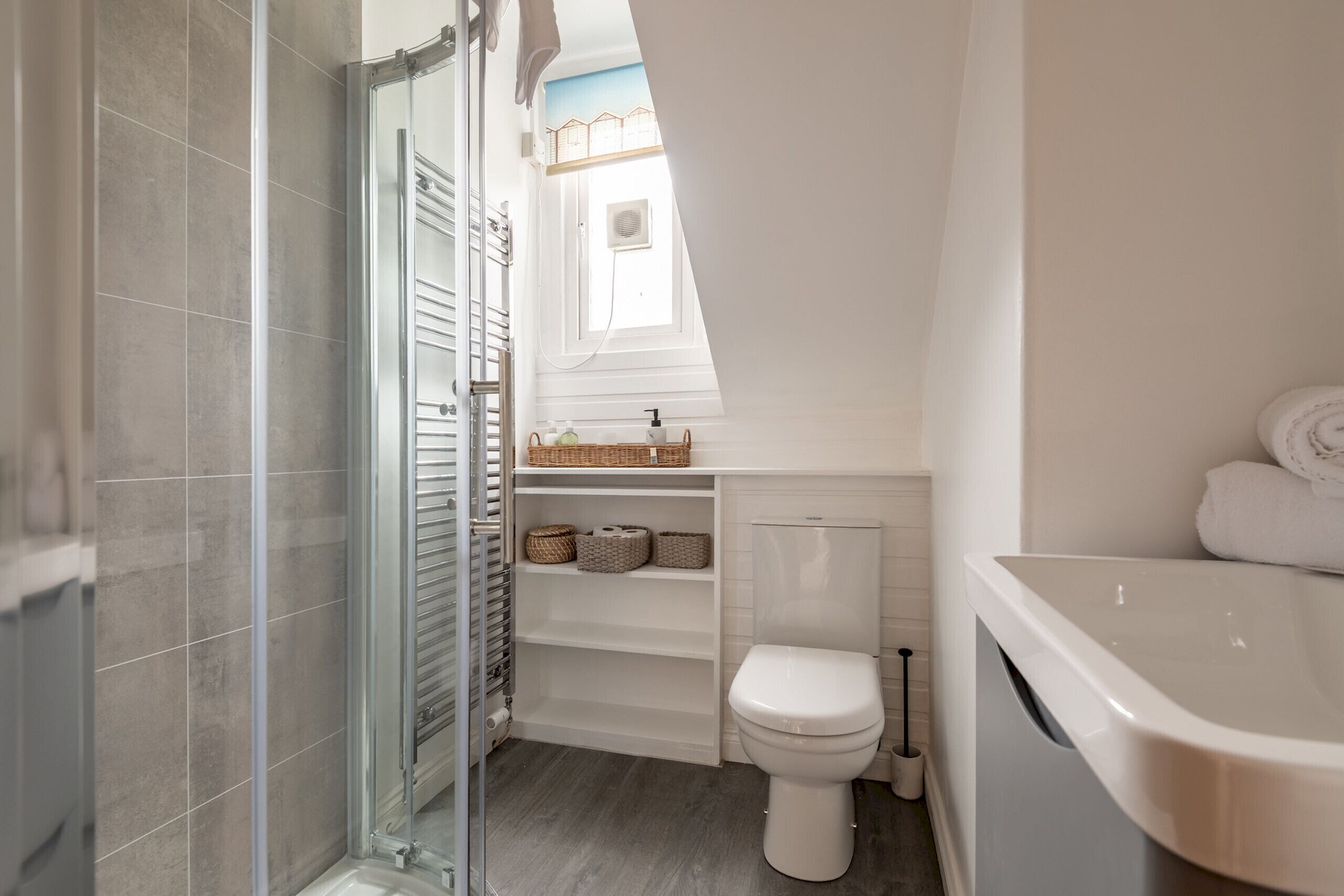Une salle de bain de taille réduite, équipée d’une douche, de toilettes et d’une baignoire.