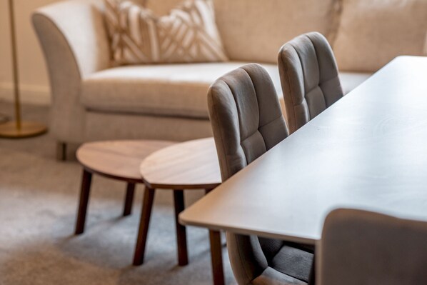 A modern living room with a sofa, two chairs, and a table.
