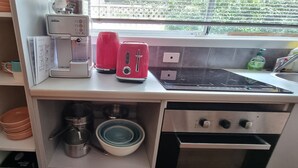 A kitchen with a coffee maker, toaster, and stove.