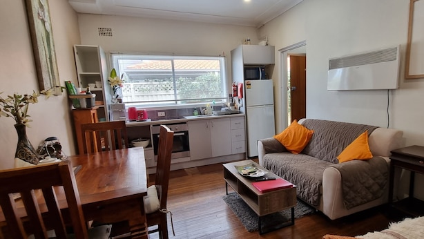 A compact living space with a dining area, kitchenette, and seating area.