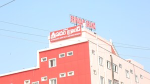 A building with a red facade and multiple windows. There are two signs on top: one reads "SRIPADAM GRAND" and the other "SUTUR HOTEL." - SRIPADAM GRAND (Chilakaluripet)