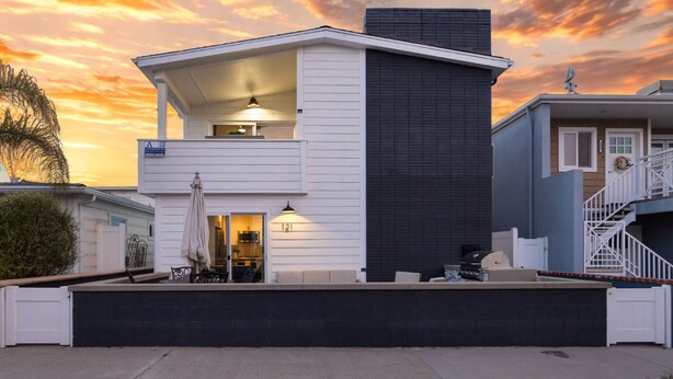 A two-story house with a balcony, a garage, and a covered patio area. - Steps to Sand! 2 Homes in 1 – Sleeps 17, Outdoor Space, Walk to Shops & Dining (Newport Beach)
