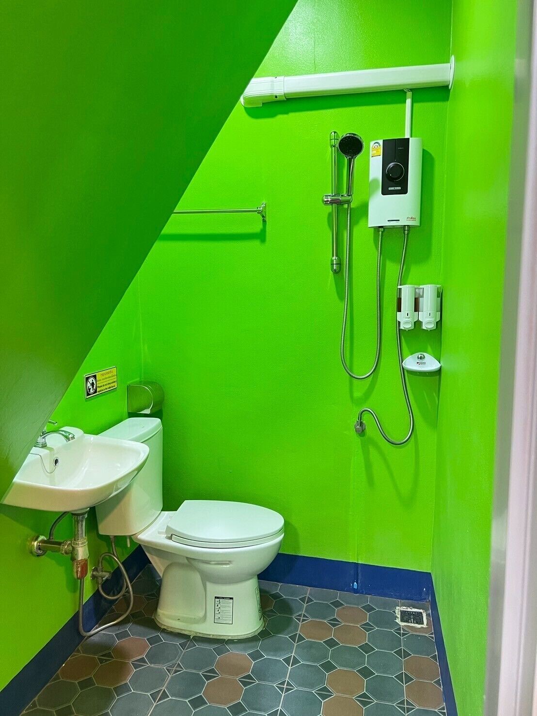 Une salle de bain avec des toilettes blanches, un lavabo et une douche.