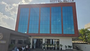 A hotel with a modern facade, large windows, and a sign indicating a restaurant on the ground floor. - Hotel Elite (Bhachau)