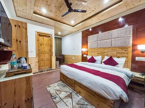Un dormitorio con estructura de madera, cama, ventilador de techo y mesita de noche.