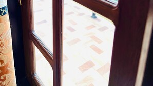 A wooden door with a brass handle, leading to an outdoor area with a tiled floor and a metal railing. - 5-bedroom villa in wonderful Negombo, 10 mins away from Airport & Beach. (Negombo)