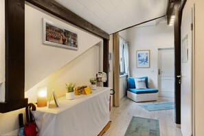 Un vestíbulo de hotel con una recepción, un sofá azul y una escalera.