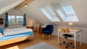 A bedroom with a loft bed, a desk, a chair, and skylights. - Holiday Home 'Backhaus' with Mountain View, Private Terrace and Private Garden (Lauterbach)